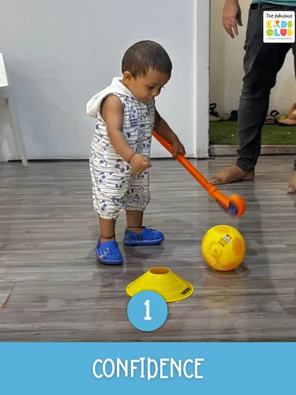 This little one is practicing hand-eye coordination with a hockey stick and ball. Every successful attempt builds confidence and a sense of accomplishment.