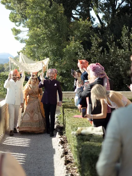 The bride's grand entrance under a phoolon ki chadar, with the beautiful Italian landscape in the background. A perfect blend of Indian tradition and international destination beauty.