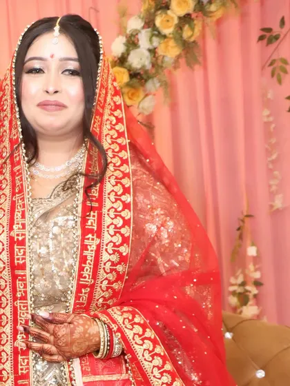 The bride with her red dupatta, adding a pop of traditional color to her golden engagement outfit.
