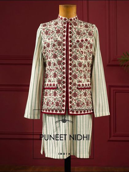 A striped kurta in off-white paired with a stunning red and white Kashmiri art inspired jacket. A vibrant and artistic choice for any celebration.
