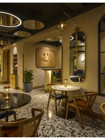 The interior of Klap restaurant in Khan Market is designed with a maximalist, vintage romance. Custom terrazzo floors, curved walls, and strategically placed mirrors create an intimate and playful dining atmosphere.