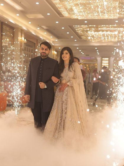 A grand entrance! Kanika and her partner make their way through sparklers, and her makeup stays flawless.