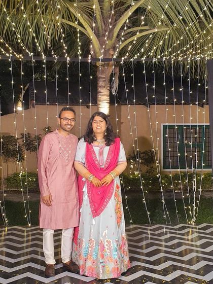 A happy couple at a wedding event. My client is wearing a beautiful pastel blue lehenga with colorful floral embroidery and a bright pink dupatta.