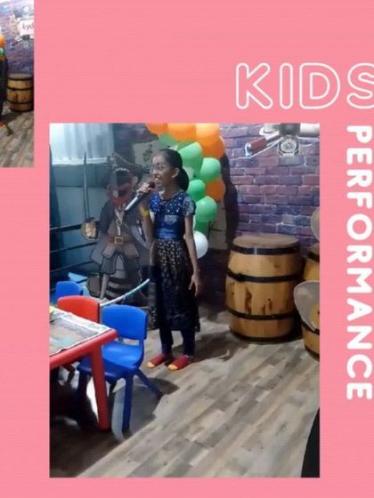A young girl sings into a microphone during a kids' performance event at our Bannerghatta Road location, showcasing the talent we nurture.