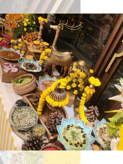 A festive grazing table decorated with yellow marigolds and golden deer figurines. This setup for a Teej celebration combines traditional festive elements with our signature abundant food styling.