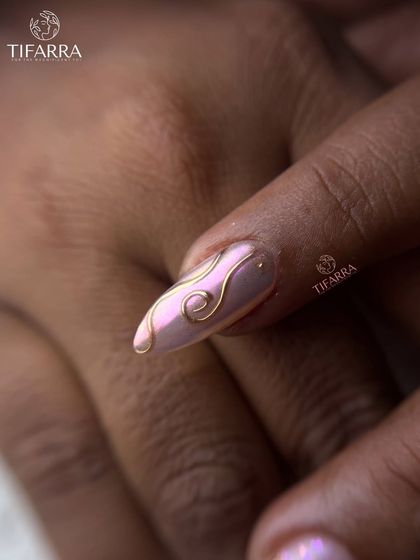 A single nail showcasing the elegant swirls of our 3D gold line work over an iridescent pink chrome base.