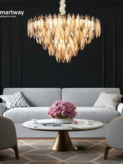 This chandelier with downward-pointing crystal leaves creates a beautiful, focused light, perfect for highlighting a sofa or a center table. The warm gold tone adds a luxurious feel to the living room.