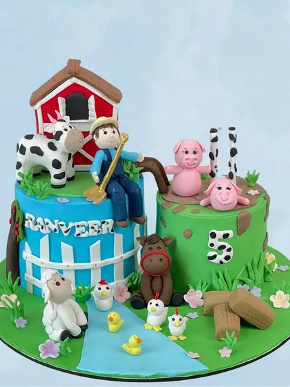 Old MacDonald had a farm, and it was delicious! This farm-themed cake for Ranveer's 5th birthday is packed with cute, edible farm animals, a barn, and a farmer.