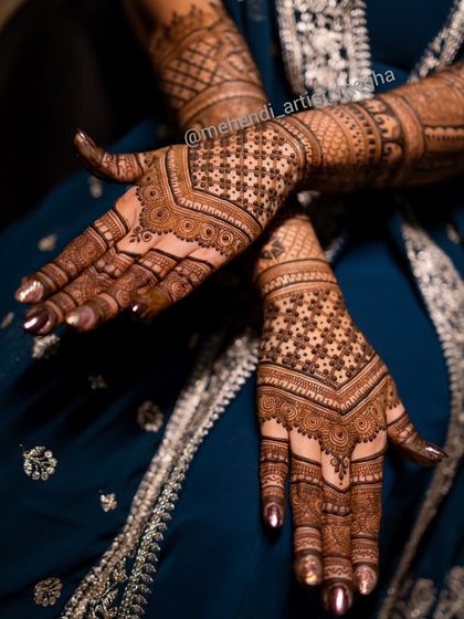 A geometric design for the back of the hands, featuring a V-shape pattern filled with intricate star-like jaal work. This style is modern, chic, and very eye-catching.