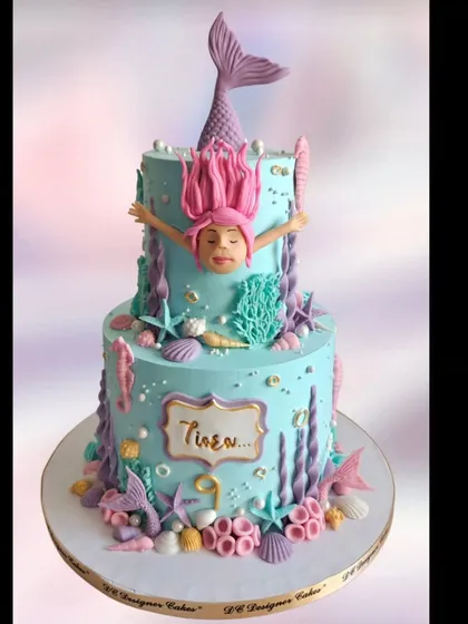 A fun take on the mermaid theme, this two-tier cake shows a mermaid diving into the water. The design uses whipped cream to create beautiful underwater details like coral and starfish.