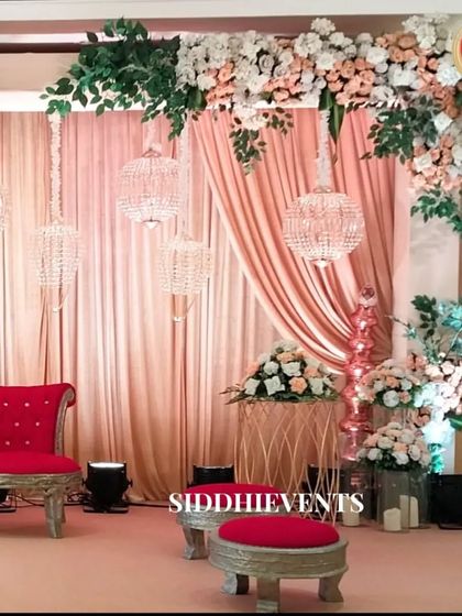A closer look at the contrast between the soft, romantic elements like the chandeliers and florals, and the passionate red of the traditional seating.
