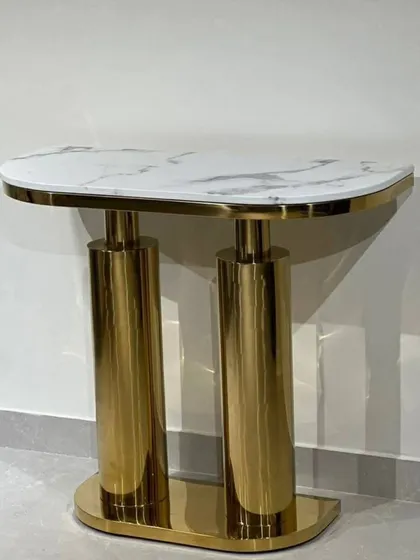 A luxurious console table with a white marble top and a gleaming gold-finished cylindrical base. Perfect for entryways or hallways.