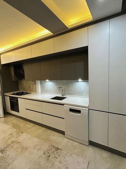 Another perspective of the Emmar Palm Springs kitchen, highlighting the clean lines and the effective use of space. The design proves that a galley layout can be both highly functional and aesthetically pleasing.