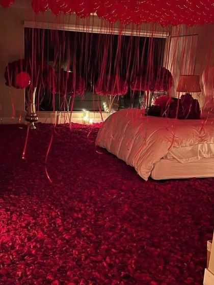 For the ultimate romantic gesture, the entire floor is covered in a thick carpet of red rose petals, creating an unforgettable visual.