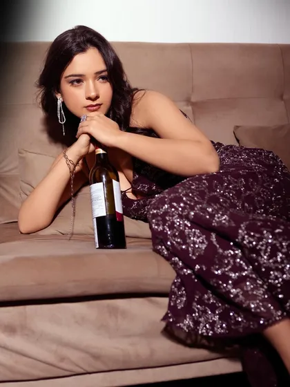 A moody and glamorous party look. The makeup features a soft smokey eye and a neutral lip, complementing the sparkling purple dress for a night out.