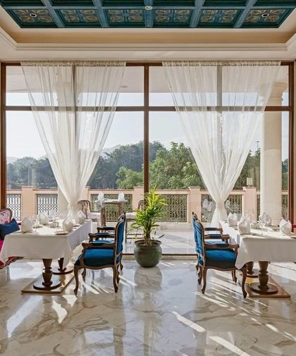 Sunlight fills this dining area at the IHCL in Haridwar, illuminating the sheer curtains and marble floors. I used pops of color in the fuchsia and blue seating to create a vibrant contrast against the stately white columns.