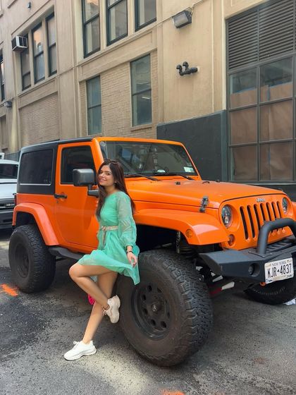Posing with a cool orange Jeep in NYC. I always look for unique photo opportunities that capture the vibe of the city.