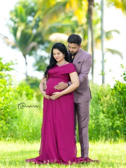 A romantic couple's portrait in a beautiful garden setting. The mother-to-be's wine-colored gown adds a touch of elegance.