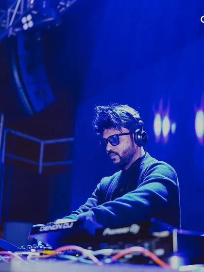 A DJ focused on the mix during a New Year's set. We book professional artists who are masters of their craft to deliver a seamless musical journey.