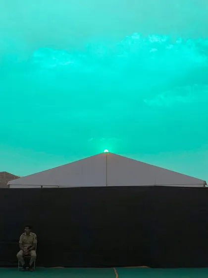 A surreal, color-shifted version of the sunset scene, with the sky turned a bright, unnatural turquoise.