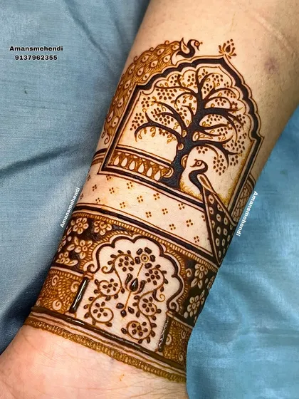Another view of the peacock and tree of life arm band, this time with an additional architectural element below it, adding more depth to the design.