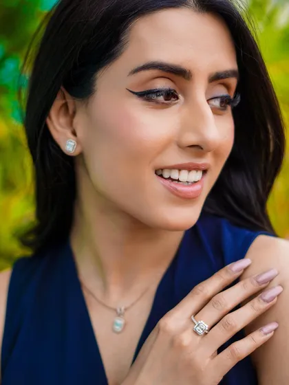 A close-up lifestyle shot focusing on a jewelry set. By using a natural, leafy background, the delicate ring, necklace, and earrings stand out, helping customers imagine wearing these beautiful pieces themselves.