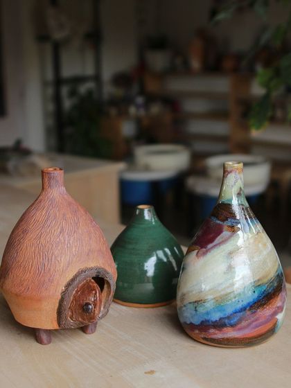 A trio of unique vases from our professional students, each telling a different story through form and surface, from a carved animal home to a multi colored abstract piece.