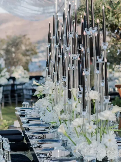 A dramatic and elegant dinner setup in Turkey, with tall black candles and white florals creating a striking contrast. This is how we execute a bold vision with precision and artistry.