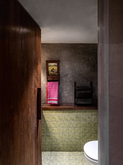 Even the washroom at the Eka store continues the design narrative. We used earthy green tiles, an exposed concrete finish, and repurposed wood for the door handle and towel rack to create a space that feels raw, natural, and familiar.
