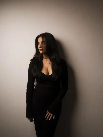A studio session with a model in a black dress, showcasing a range of poses from pensive to powerful. The lighting is controlled to sculpt the subject and create a sophisticated mood.