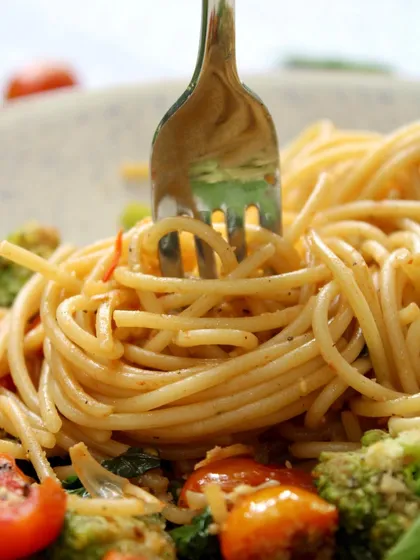 Twirling a forkful of our Farmer's Style Spaghetti. You can see the delicious sauce clinging to every strand of pasta, promising a flavorful bite.