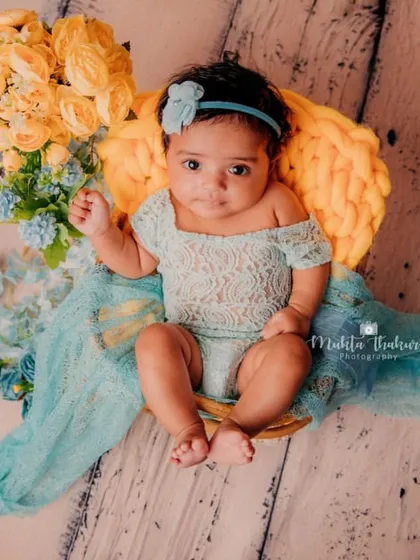 A beautiful portrait of this 3-month-old baby girl, showcasing her delicate features and the lovely textures of her outfit and props.