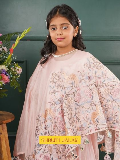 A close-up of my pink cape set, showing the delicate floral print and tassel details. It’s a perfect outfit for a little girl who loves to feel like a fairy tale princess.