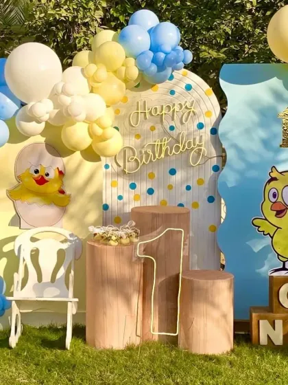 The central photo spot for the duckling party, with a special chair for the birthday boy, rustic props, and a glowing number '1'.