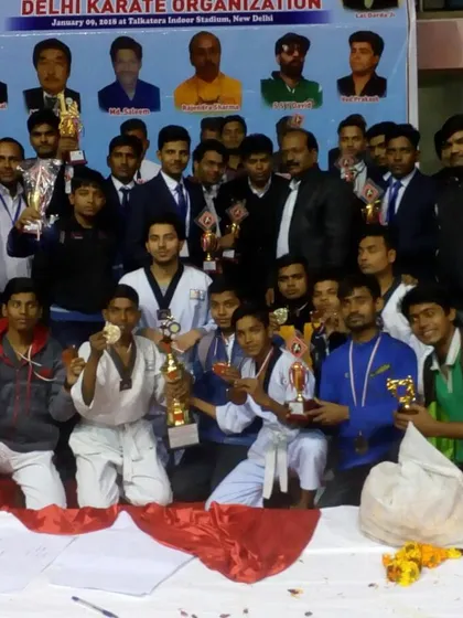 The entire team posing with their trophies and medals after a successful national karate championship. This is what teamwork and dedication look like.