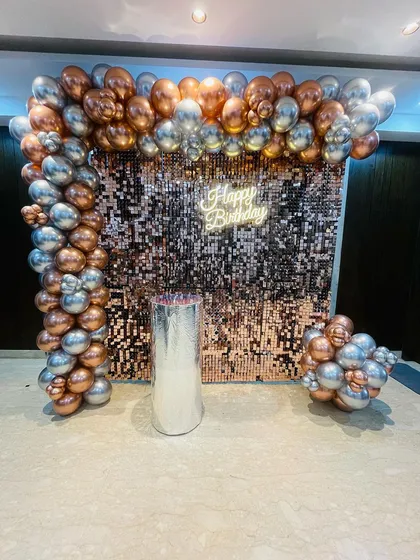 A beautiful rose gold and silver shimmer wall setup. The metallic balloons in the arch perfectly complement the sparkling backdrop for a very glamorous effect.