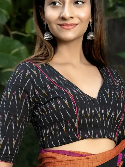 A full view of the black ikat V-neck blouse. The front-open style and elbow-length sleeves make it a comfortable and chic choice for pairing with a variety of sarees.