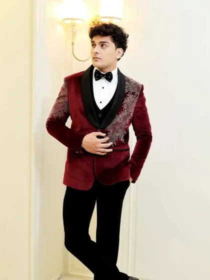 A rich maroon velvet tuxedo jacket with delicate silver crystal work on the shoulders. This is a great option for a winter wedding or a formal evening event.