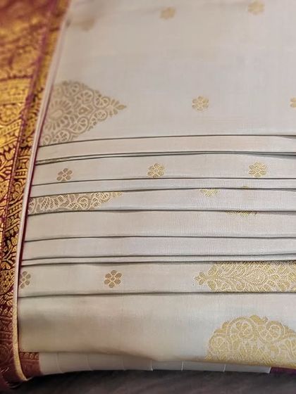 The back view of the folded off-white and red bridal saree.