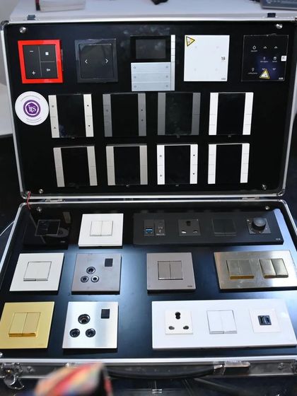 A briefcase displaying a wide variety of smart switches and keypads from brands like ABB and Roehn, demonstrating the extensive range of styles and finishes I offer.