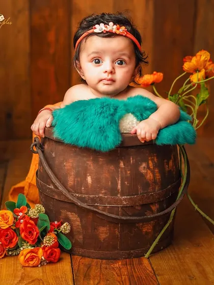 A full view of the bucket pose, a safe and cute way to photograph babies who are confidently sitting up.