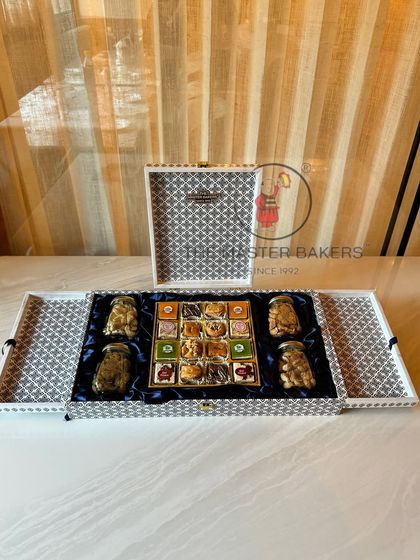 A sophisticated black and white patterned gift box that exudes modern luxury. This hamper is filled with four jars of premium nuts and a delicious assortment of our handcrafted sweets.