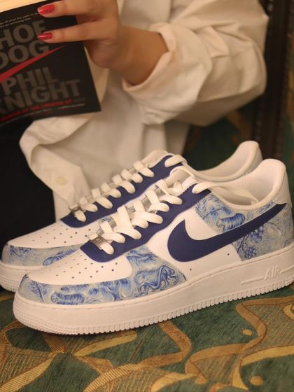 Reading "Shoe Dog" by Nike's founder, Phil Knight, with my custom Dior-inspired Nikes. It feels like the perfect combination of sneaker history and high-fashion art.