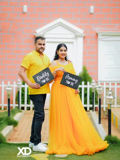 A fun and creative shot of a couple holding "Daddy to be" and "Mommy to be" chalkboards.