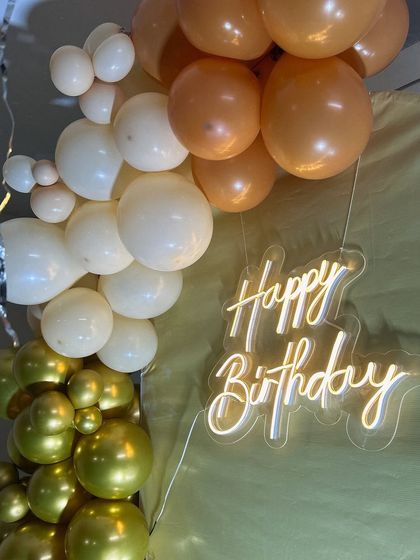 A detail shot of the 'Happy Birthday' neon sign, which adds a modern and trendy touch to any decor.