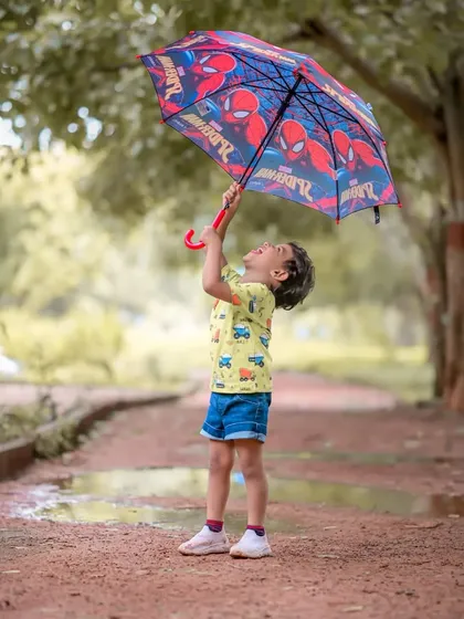Even superheroes need to stay dry. This playful shot with a Spiderman umbrella shows how we can incorporate your child's favorite characters into the photoshoot for a fun and personal touch.