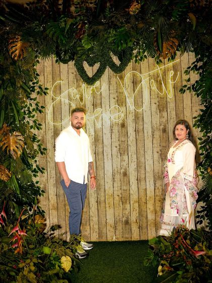 A 'Save the Date' shot using our neon sign against a rustic, leafy backdrop.