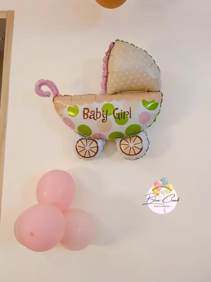 A simple 'Baby Girl' foil balloon with a small cluster of pink balloons for a subtle celebration.
