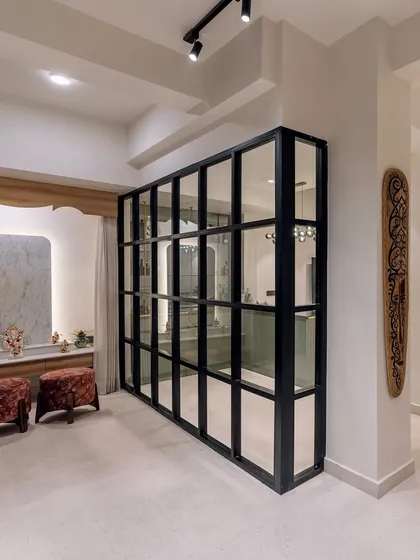 A stylish glass partition separates the bar area from the pooja space in 'Project Lily', creating distinct zones while maintaining an open feel.