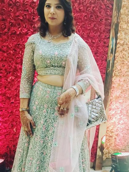 A client looking elegant in a mint green lehenga with pink floral embroidery. This is a refreshing and beautiful color combination available for rent.